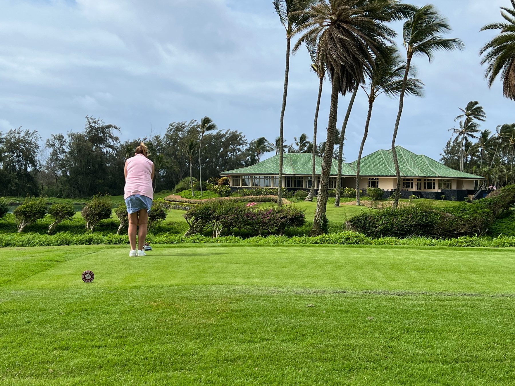 Teeing off toward the green-roofed clubhouse