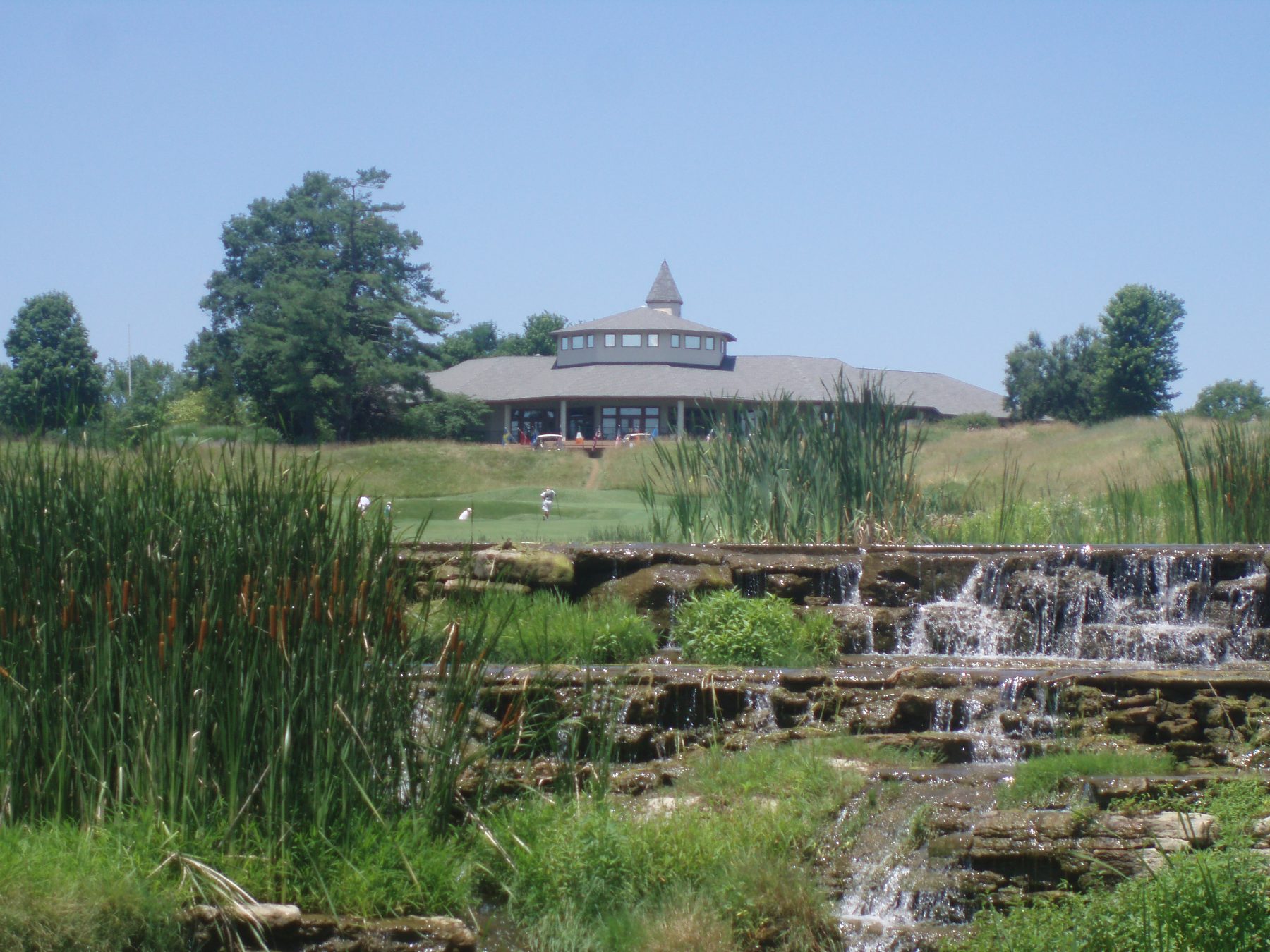 The clubhouse from across the water. That waterfall is real and it is in play.